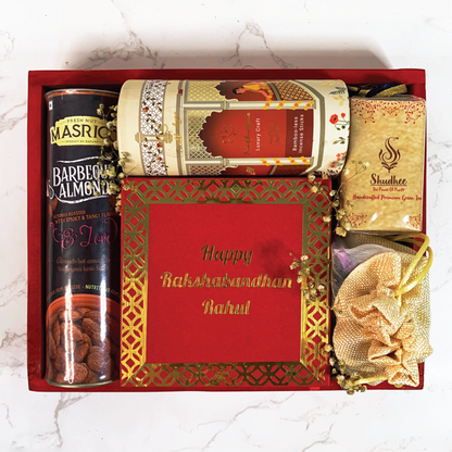 Assortment of products in a ibrant red festive hamper with flavoured dry fruits, aromatherapy incense sticks, mithai scented candles, chocolates and organic green tea