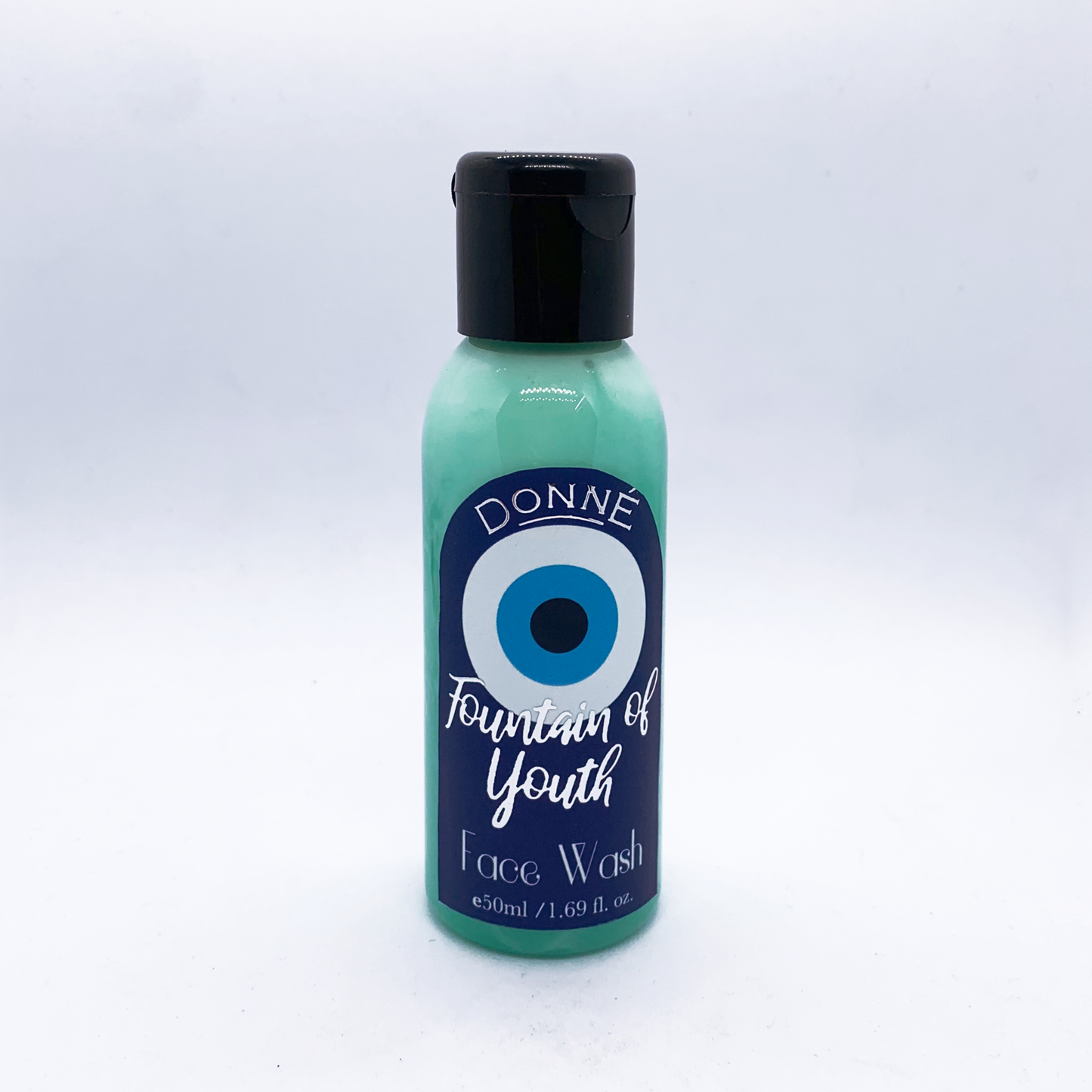 Fountain of Youth - a face wash against a white background with a black lid, evil eye labels with silver accents