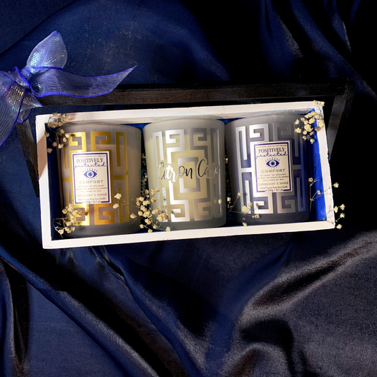 Set of three container candles with greek key design motifs with fragrance names, and in a decorative wooden crate hamper and baby's breath flowers for decor