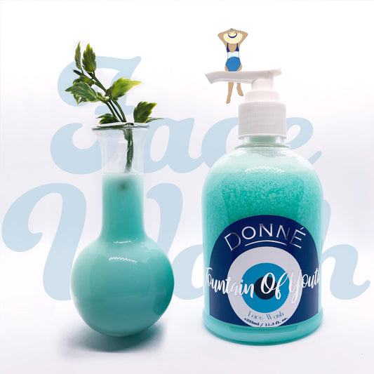 Light blue face wash in a dome bottle with a texture swatch in a glass beaker with a leaf and evil eye label with metallic accents with an illustrated woman sitting on the pump